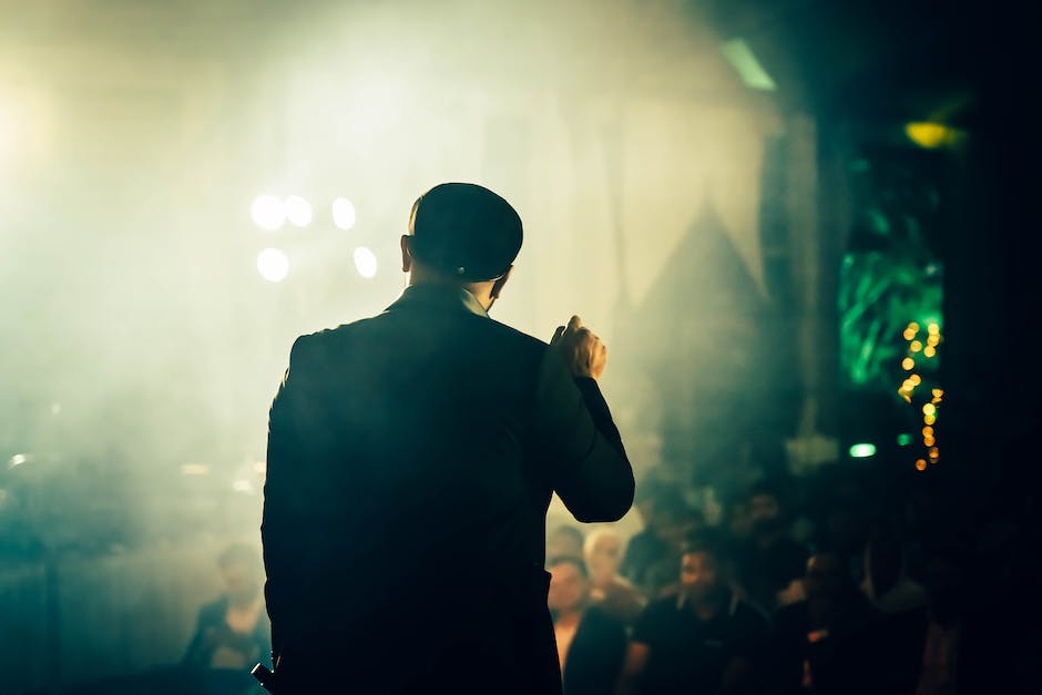 Image of a marketing influencer holding a microphone and speaking to an audience